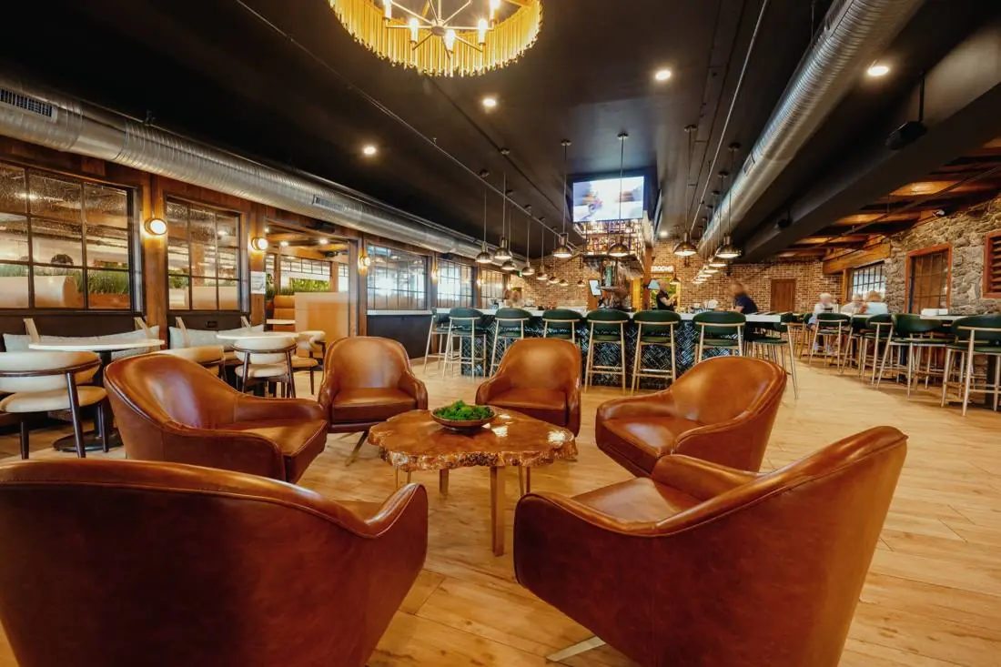 The main dining room with leather armchairs and the bar beyond
