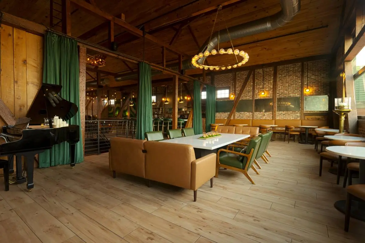 The lounge from an angle, showing the piano, seating, and wood floors