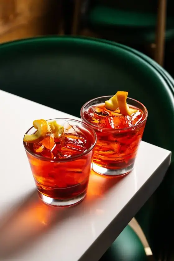 Two negroni cocktails with orange peel garnish