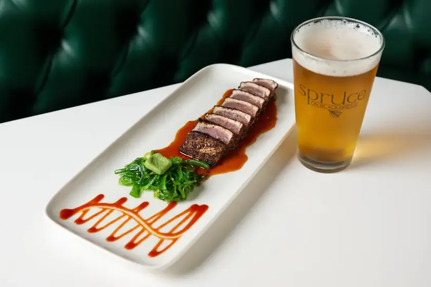 Seared tuna slices with seaweed salad and wasabi beside a Spruce on Blackbridge pint of beer